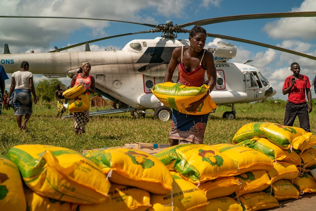 Women unload humanitarian aid from a World Food Programme helicopter in Bebedo, Mozambique, April 8, 2019, after Cyclone Idai. Context for aid logistics; this image does not document Palantir software in use.